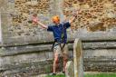 Rev Mark Capron celebrates after abseiling down the tower at St Nicholas Church at Dersingham