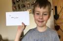 Harry and Rebecca Beaumont have delivered bunches of flowers and rainbows to their neighbours. Here Harry is pictured with a thank-you letter from one of his neighbours. Picture: Rebecca Beaumont