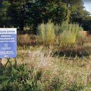 A sign advertising the fact that outline planning permission for 15 homes already exists on the site.